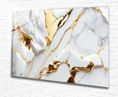 a white and gold marble wall hanging on a brick wall with an abstract design in the middle