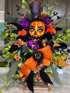 a halloween decoration with pumpkins and flowers