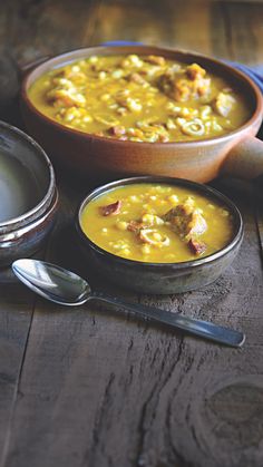 two bowls filled with soup on top of a wooden table