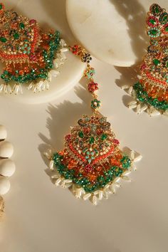 Elevate your festive attire to dreamy perfection with the Sarah - Chandelier Earrings & Maang Tikka Set, an embodiment of grandeur and allure. This exquisite earrings & maang tikka set is meticulously embellished with the splendor of multi-color stones and embellishments, adding a touch of magic to your look. The set includes a pair of stunning chandelier earrings and a maang tikka, each designed to captivate. With an approximate earring length of 3.5 inches, they are a symbol of elegance and op Festive Fusion Chandelier Earrings With Stone Work, Fusion Kundan Chandelier Earrings With Latkans, Fusion Style Kundan Chandelier Earrings With Latkans, Festive Fusion Chandelier Earrings, Festive Temple Jewelry Chandelier Dangle Earrings, Temple Jewelry Style Chandelier Earrings For Celebration, Temple Style Chandelier Earrings With Stone Work For Celebrations, Temple Jewelry Tikka For Eid Celebration, Temple Jewelry Style Tikka For Eid Celebration