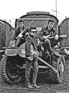 an old black and white photo of three men with guitars