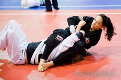 a woman in black and white is on the ground with her hands behind her back