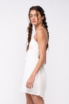 We're dreaming of a beautiful sunny day, and it starts with the Kristen White Halter Mini Dress! White woven fabric forms a cutout tie bodice with a plunging V-neckline that meets a strappy, open back and an elastic waistband. The attached mini-skirt has an elastic waist. DETAILS & CARE 80% Rayon, 20% Polyester/LINING: Polyester. Hand wash cold or dry clean. Imported. White Backless Dress With Lace-up Back For Summer, Spring V-neck Halter Dress With Crisscross Straps, Strappy Summer Dress With Lace-up Back, Summer Strappy Maxi Dress With Tie Straps, Spring Strappy Maxi Dress With Tie Straps, Halter Neck Backless Dress With Lace-up Back For Beach, Backless Summer Halter Dress With Lace-up Back, Beach Halter Neck Backless Dress With Lace-up Back, Summer Dresses With Crisscross Straps For Day Out