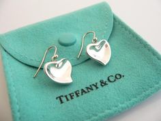 Overview:Time to pull your hair back and show off your awesome earrings!  Offered for sale is a gorgeous and elegant pair of Tiffany and Co. Sterling Silver Peretti Carved Heart Dangling earrings.   This pair looks fabulous, cosmopolitan, and yet retains a very dainty and feminine touch to it.  Extremely elegant and comfortable piece! You will feel playful, modern and super stylish while wearing these earrings.  Great pair to wear for work, a night in town, at a party, or just going to dinner Valentine's Day Polished Finish Earrings, Valentine's Day Gift Earrings With Polished Finish, Luxury Silver Heart-shaped Earrings, Luxury Heart-shaped Drop Earrings For Valentine's Day, Luxury Pierced Earrings For Valentine's Day, Elegant Heart Earrings For Valentine's Day Anniversary, Elegant Pierced Heart Earrings For Valentine's Day, Sterling Silver Earrings For Anniversary And Mother's Day, Sterling Silver Earrings For Mother's Day Anniversary