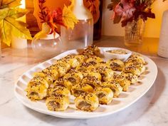 a white plate topped with lots of food on top of a counter next to vases