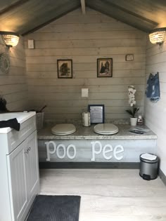 there is a small bathroom with two toilets and a counter in the corner that says poo pee