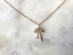 "Dress up your outfit with this dainty bow ribbon pendant necklace!  JEWELRY DETAILS: ◦ Necklace chain: 16K gold plated over brass ◦ Pendant: 18K gold plated over brass, cubic zirconia ◦ Pendant measures 0.75\" length, 0.51\" width ◦ Necklace length options: 15\", 16\", 17\", 18\" ◦ Nickle-free and lead-free jewelry JEWELRY CARE TIPS: ◦ Store jewelry in a cool and dry place, keep away from moisture ◦ Remove before exercising, sleeping, and entering water ◦ Avoid contact with perfumes, lotions an Gold Necklace With Ribbon For Gift, Gold Necklace With Ribbon Perfect For Gifts, Adjustable Necklace With Decorative Bow As Gift, Adjustable Necklace With Decorative Bow For Gifts, Pink Bow Jewelry Gift, Feminine Ribbon Necklace As Gift, Delicate Ribbon Necklace Gift, Feminine Ribbon Necklace For Gift, Delicate Ribbon Necklace For Gifts