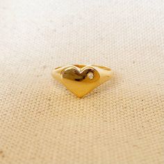 A cute heart with cubic zirconia accent to shiny your soul. 18k Gold Filled ring featuring a heart shaped polished top with a single micro pave Cubic Zirconia Stone. * Metal: 18k Gold Filled * Weights 1.0 grams * Hypoallergenic jewelry * Handcrafted in Brazil Learn how to care for your jewelry with these easy instructions. Properly handling and caring for your ArtBossa jewelry is essential in maintaining its pristine condition. 1. Keep your gold-filled jewelry away from chemicals and cleaning pr Heart Shaped Single Diamond Ring For Gift, Heart Shaped Single Diamond Gift Ring, Valentine's Day Yellow Gold Heart Ring With Cubic Zirconia, Gold Diamond Heart Ring For Valentine's Day, Heart-shaped Single Diamond Ring Gift, 14k Gold Heart Ring With Single Diamond For Gift, Heart-shaped Single Diamond Gift Ring, Heart-shaped Diamond Ring With Vs Clarity, Gold Diamond Heart Ring As Gift