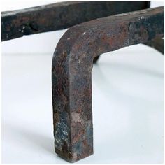 an old rusted metal bench sitting on top of a white table