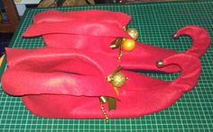 a red cloth with gold decorations on it sitting on a table next to a pair of scissors