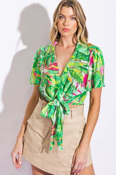 A printed woven top featuring shirt collar, V neckline, flutter sleeve and front tie. Matching pant IP8428Details:Self : 100% PolyesterSize & Fit- Model is 5`8" And Wearing Size Small- Measurements Taken From Size Small- Approx. Length: 16" Chic Green Tops With Tie Waist, Summer Printed Tie Neck Tops, Printed Tie Neck Tops For Summer, Summer V-neck Blouse With Tie Waist, Green Printed Blouse For Day Out, Printed Green Blouse For Day Out, Green Tie Neck Top For Summer, Spring Green Blouse With Collared Neckline, Chic Green Blouse For Vacation