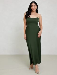 a woman in a green dress posing for the camera with her hands on her hips