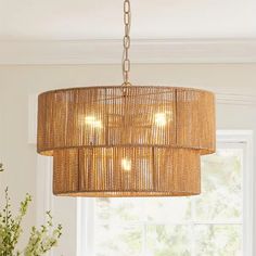 a chandelier hanging from a ceiling in a living room with white walls and windows