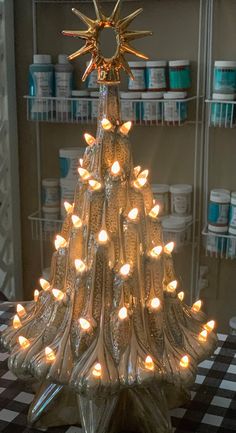 a glass christmas tree with lit candles in it