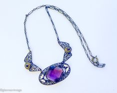 ~ 1920s gorgeous old brass filigree necklace with purple glass ~ Large faceted purple glass stone ~Old wonderful chain, paper clip style ~ Delicate enamel leaves ~ Excellent condition Length- 18" (45.5 cm) Drop when held- 8.5" (21.59 cm) More Fantastic Vintage Jewelry:  glennasvintageshop.etsy.com Additional Vintage in our sister shop Glenna's Jewels:  glennasjewels.etsy.com Instagram @glennas_clothing Facebook https://www.facebook.com/glennasclothing Purple Filigree Jewelry For Jewelry Making, Formal Purple Metal Necklace, Antique Handmade Purple Jewelry, Handmade Antique Purple Jewelry, Antique Purple Metal Jewelry, Vintage Purple Filigree Jewelry, Purple Art Deco Necklace For Gift, Antique Oval Purple Necklaces, Purple Pendant Necklace With Filigree