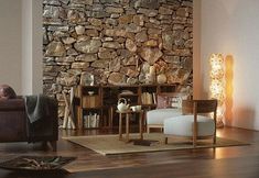 a living room filled with furniture and a stone wall