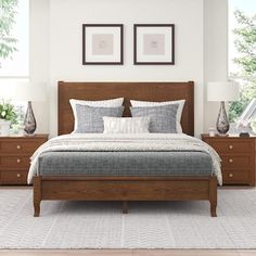 a large bed sitting in a bedroom next to two framed pictures on the wall above it