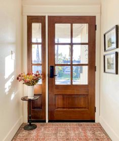 a vase with flowers is sitting on the floor in front of a door