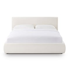 a bed with white sheets and pillows on it