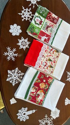 three napkins on top of each other with snowflakes and christmas decorations in the background