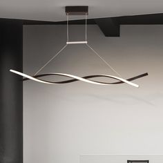 a modern chandelier hanging from the ceiling in a room with black and white walls