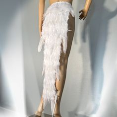 a female mannequin wearing a white feathered skirt and high heels with her hands on her hips