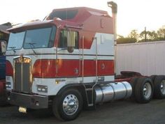 a red and white semi truck parked in a parking lot