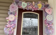 a door decorated with pink, purple and green mesh wreaths for valentine's day