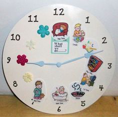 a white clock with various stickers on it's face and numbers in different languages