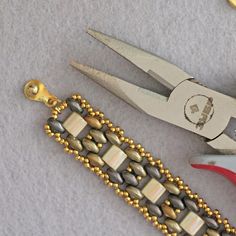 two pairs of scissors and some beading on a table next to each other,