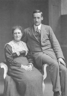 an old black and white photo of a man and woman sitting on a chair together