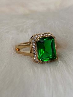 Talk about green with envy! The Emerald Sage Block Ring is one of this seasons most desired rings. This jewel features a radiant cut emerald CZ, about 13 mm H x 12mm W, showcased within a cubic zirconia encrusted frame and is secured on a split smooth open band. The green-eyed monster is bound to appear when rocking this gal! Mix and match with these emerald embellished jewels! - The Jeweled Emerald Necklace - The Emerald Jade Pendant Necklace - The Verdi Emerald Ring Available in 24K gold or rhodium plating over steel Patent plating & sealant technology to ensure durability and long lasting wear Made in Los Angeles, CA | Nickel & Lead Free Square Cut Emerald Rings In Gold, Square Cut Emerald Gold Rings, Green Rectangular Stone Ring, Green Rectangular Diamond Ring With Prong Setting, Gold Emerald Ring With Radiant Cut, Gold Emerald Diamond Ring With Radiant Cut, Gold Radiant Cut Emerald Rings, Formal Green Rectangular Diamond Ring, Green Cubic Zirconia Ring With Halo Setting