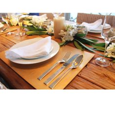 a place setting with silverware and flowers on the table for two people to eat