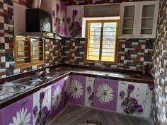 a kitchen with purple and white painted flowers on the cabinets, counter tops and backsplash