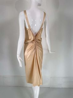 For Sale on 1stDibs - John Galliano, old Hollywood glamourous gold satin evening dress with a plunge V neckline and chiffon woven shirred center front, The back features a row Elegant Gold V-neck Evening Dress, Gold V-neck Evening Dress For Summer, Glamorous Ruched Evening Dress For Dinner, Gold Draped Ruched Dress, Gold Backless Evening Dress, Gold Ruched Draped Dress, Gold Backless Summer Evening Dress, Summer Backless Gold Evening Dress, Summer Gold Backless Evening Dress