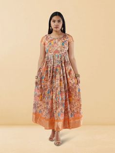 Embrace elegance in our Tranquil Threads Cream Kalankari Print Ankle Length Dress. This exquisite dress features a delicate cream Kalankari print on high-quality fabric, exuding an Indo Western charm. The ankle-length design adds a touch of sophistication, making it ideal for various occasions. Care instructions include gentle hand wash in cold water to maintain the fabric's integrity and intricate print details. Orange Chanderi Dress With Cutdana Details, Sleeveless Anarkali Dress With Printed Motifs, Sleeveless Chanderi Anarkali Dress, Navratri Orange Dresses With Printed Motifs, Orange Dresses With Printed Motifs For Navratri, Traditional Dresses With Printed Motifs For Transitional Season, Transitional Multicolor Printed Dresses, Transitional Chanderi Block Print Dresses, Multicolor Chanderi Block Print Dress