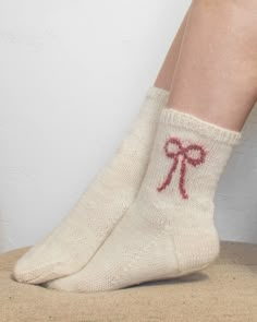 a woman's legs wearing socks with red bows on them and the bottom of her sock