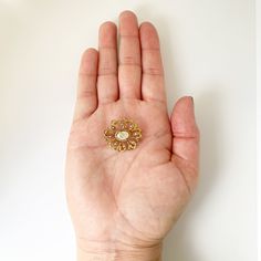 The listing is for a Vintage Seed Pearl Brooch. The brooch features a prong set mother of pearl flat cabochon with beautiful open work swirling gold frame. The decoratively engraved gold frame is accented with 8 small seed pearls set around the center mother of pearl flat cabochon. Measurement: 0.879 inches long x 0.982 inches wide. Weight: 3.4 grams Markings: unmarked but tests as 10K. Condition: Excellent condition. Has a working C-clasp closure. ❤All items in my shop are Estate, Vintage, and Gold Cameo Brooch For Wedding, Luxury Gold Brooches With Cabochon, Antique Gold Brooch With Cabochon Detail, Antique Gold Brooch With Cabochon, Antique Gold Brooches With Cabochon, Ornate Gold Cabochon Brooches, Elegant Yellow Gold Medallion Brooches, Luxury Gold Brooches With Intricate Design, Antique Gold Brooch With Gemstone