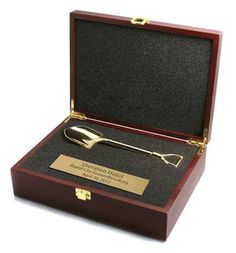 a wooden box with a spoon in it and a plaque on the lid that says,