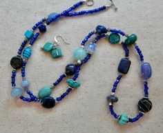 This 36 inch necklace is made from small dark blue beads with other larger beads in turquoise, light blue, and dark blue.  There are also silver accent beads.  It has a small toggle clasp.  The matching earrings are included.  This long necklace will look great with blues, white, black and beige.  It is very versatile. Adjustable Double Strand Turquoise Blue Necklace, Adjustable Double Strand Blue Turquoise Necklace, Blue Double Strand Bohemian Turquoise Necklace, Bohemian Double Strand Turquoise Necklace, Bohemian Blue Double Strand Turquoise Necklace, Blue Turquoise Necklace With Spacer Beads As Gift, Bohemian Blue Gemstone Beads, Blue Double Strand Natural Stones Jewelry, Blue Turquoise Necklace With Round Beads