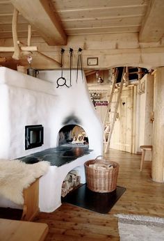 an oven in the middle of a room with wood floors and ladders on the wall