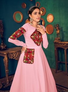 Look pretty adorning this pink color Anarkali gown in georgette material embellished with gamthi embroidery, mirror, and pearl work.
The gown comes with crepe inner material. 
The pink gown is semi-stitched can be customized up to 42 inches and the gown length is 58 inches. 
Pink color gown with gamthi work look amazing traditional can be worn at festivals like Navratri.
Disclaimer: This gown will not come with a can-can, bottom, and dupatta. Gamthi Work, Georgette Material, Belt Pocket, Embroidery Mirror, Reception Sarees, Pearl Work, Golden Saree, Mirror Work Saree, Pink Gown