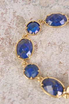 Add a touch of sophistication to your outfit with our Lapis Lazuli Stone Bracelet. Featuring shimmering, round and oval-shaped lapis lazuli gemstones with a gold finish, this bracelet will instantly elevate your style. Gold Bracelets With Lapis Lazuli And Natural Stones, Gold Lapis Lazuli Bracelet With Gemstone, Gold Lapis Lazuli Gemstone Bracelet, Elegant Lapis Lazuli Oval Cabochon Jewelry, Elegant Oval Cabochon Lapis Lazuli Jewelry, Lapis Lazuli Stone, Navy Gold, Your Outfit, Elevate Your Style