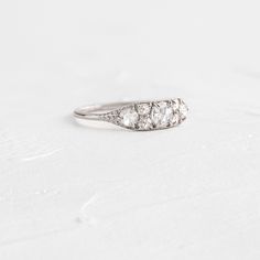 an antique three stone diamond ring on a white background with space for the wording