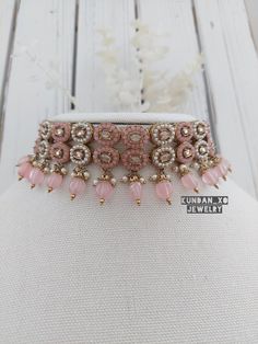 Beautiful reverse polki stone choker set with blush pink and pearl details is available for purchase. Full set comes with jhumki earrings and matching tikka.  The perfect hand crafted jewelry is sure to compliment your next outfit this season and next! Wear the pieces together or seperately for endless options. Our beautiful Indo-western design done in our most popular blush pink shade is sure to add the finishing touch to your party wear or bridal looks.  Kindly message for any further inquirie Pink Kundan Necklaces As Gift, Pink Kundan Necklaces For Gifts, Pink Tilla Necklaces For Diwali, Pink Tilla Necklace For Diwali, Pink Necklaces With Tilla For Diwali, Pink Round Jewelry Sets For Diwali, Pink Bollywood Jewelry, Pink Kundan Necklace With Hand-set Details, Pink Kundan Necklace For Festivals