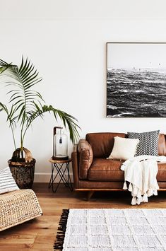 a living room filled with furniture and a large painting on the wall above it's headboard