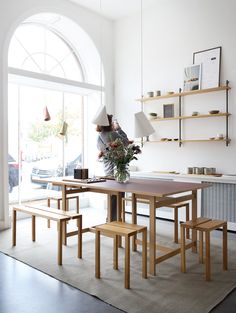 a dining room table and benches in front of a large window