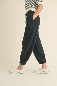 Women's Loose Pleated Joggers Drawstring Knit Lounge Pants Introducing our latest arrival: Drawstring Knit Lounge Pants! Available in two trendy colors, these pants boast a drawstring, convenient side pockets, pleated accents, and a cozy jogger style. Made with soft ribbed fabric, you'll never want to take them off. With a cute, cozy, and chic aesthetic, these pants feature a loose fit for maximum comfort. Complete the look by pairing them with our matching shirt (sold separately). Trust us, you Comfortable Drawstring Loungewear Bottoms, Comfortable Drawstring Bottoms For Loungewear, Comfortable Lounge Bottoms With Drawstring, Cozy Relaxed Fit Bottoms With Drawstring, Cozy Drawstring Sweatpants For Leisure, Solid Color Drawstring Sweatpants For Lounging, Relaxed Fit Bottoms With Drawstring For Fall, Cozy Drawstring Pants For Loungewear, Cozy Solid Color Sweatpants With Drawstring