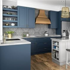 a kitchen with blue cabinets and an island in front of the countertop, has a gold pendant light hanging from the ceiling