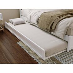 a bed with a white headboard and foot board on it's side in a bedroom